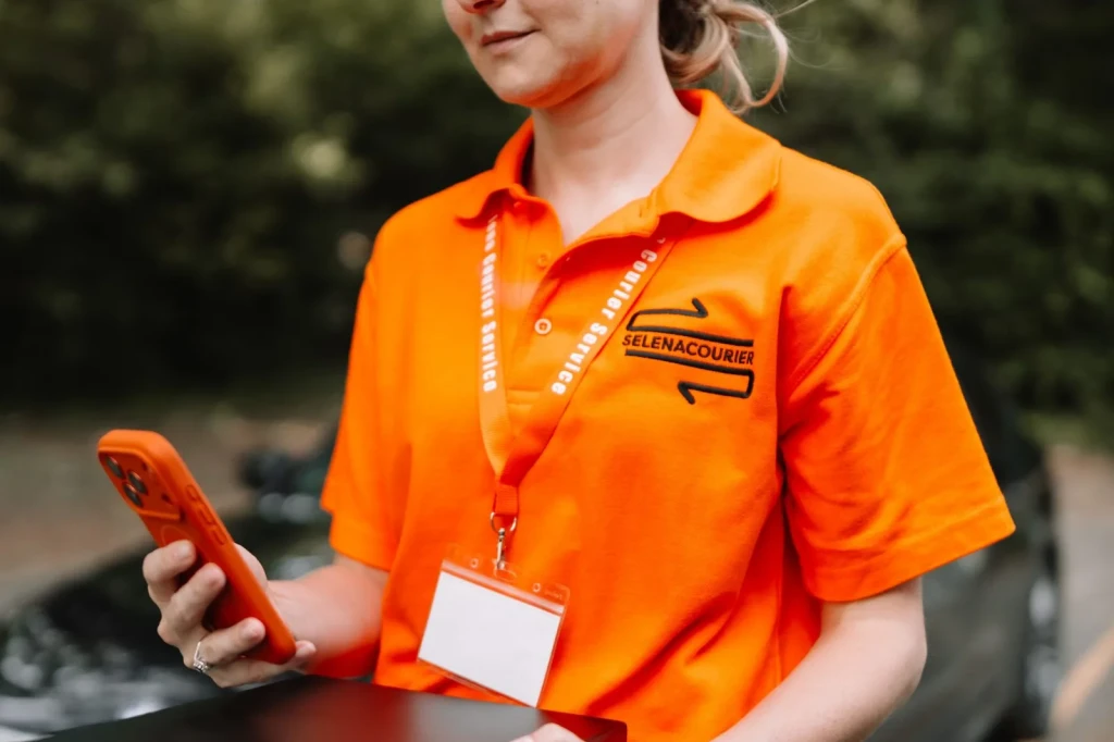 Courier checking delivery details on a phone