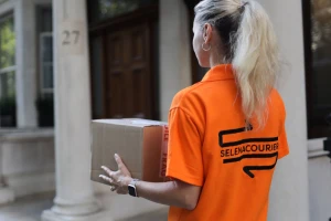 Eco-friendly courier delivering packages in London using an electric bike.