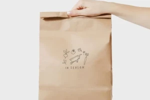 Paper takeaway bag handed over for eco-friendly delivery