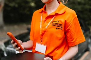 Courier confirming a delivery on a phone at the vehicle