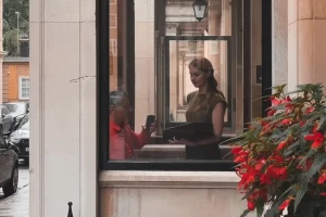 Selena courier confirming a handover on his phone with a recipient at a London building reception