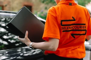 Selena courier carrying a branded box to the delivery vehicle