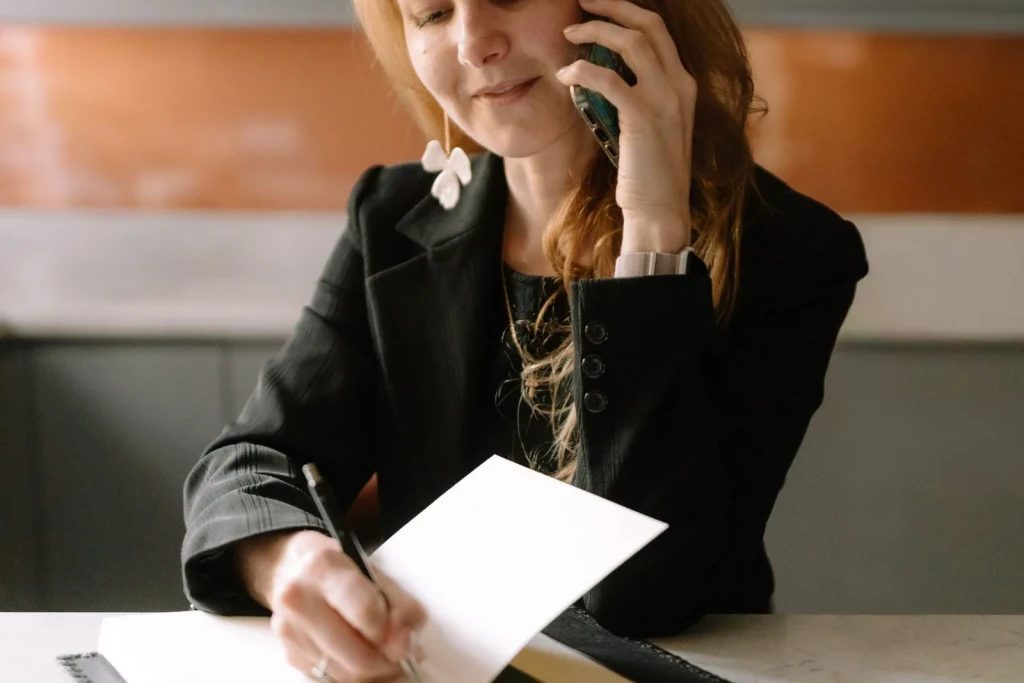 Manager reviewing a delivery document while on the phone