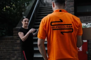 Selena courier handing over a delivery on a London street
