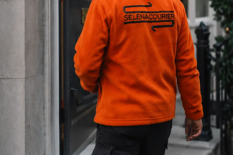 Selena courier walking to a London townhouse entrance