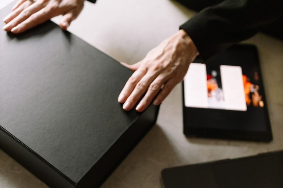 Hands preparing a presentation delivery beside a laptop