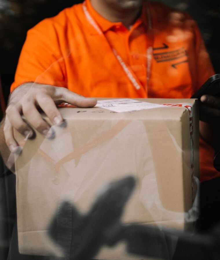 Selena courier carefully moving a parcel to the delivery vehicle
